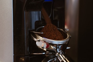 Close-up of a sleek vending machine dispensing freshly ground coffee in a modern office setting.