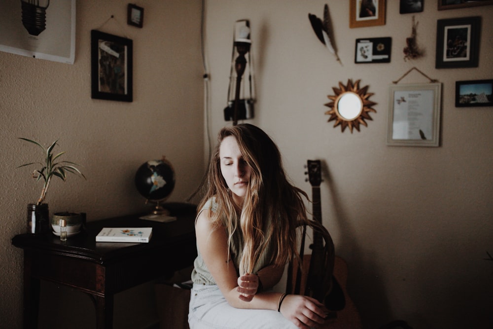 woman sitting beside table and guitar