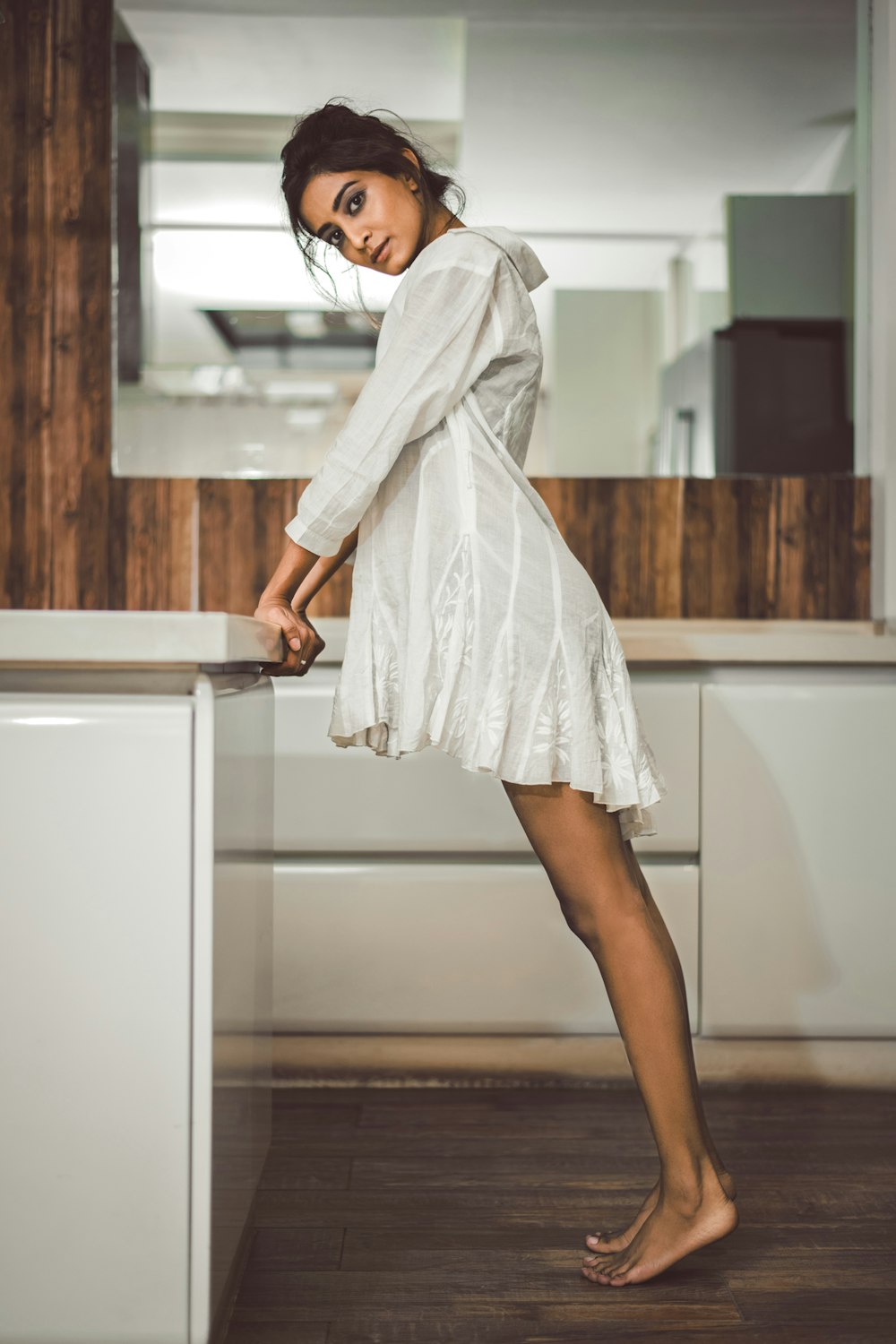 Foto de enfoque superficial de mujer con vestido blanco de manga larga