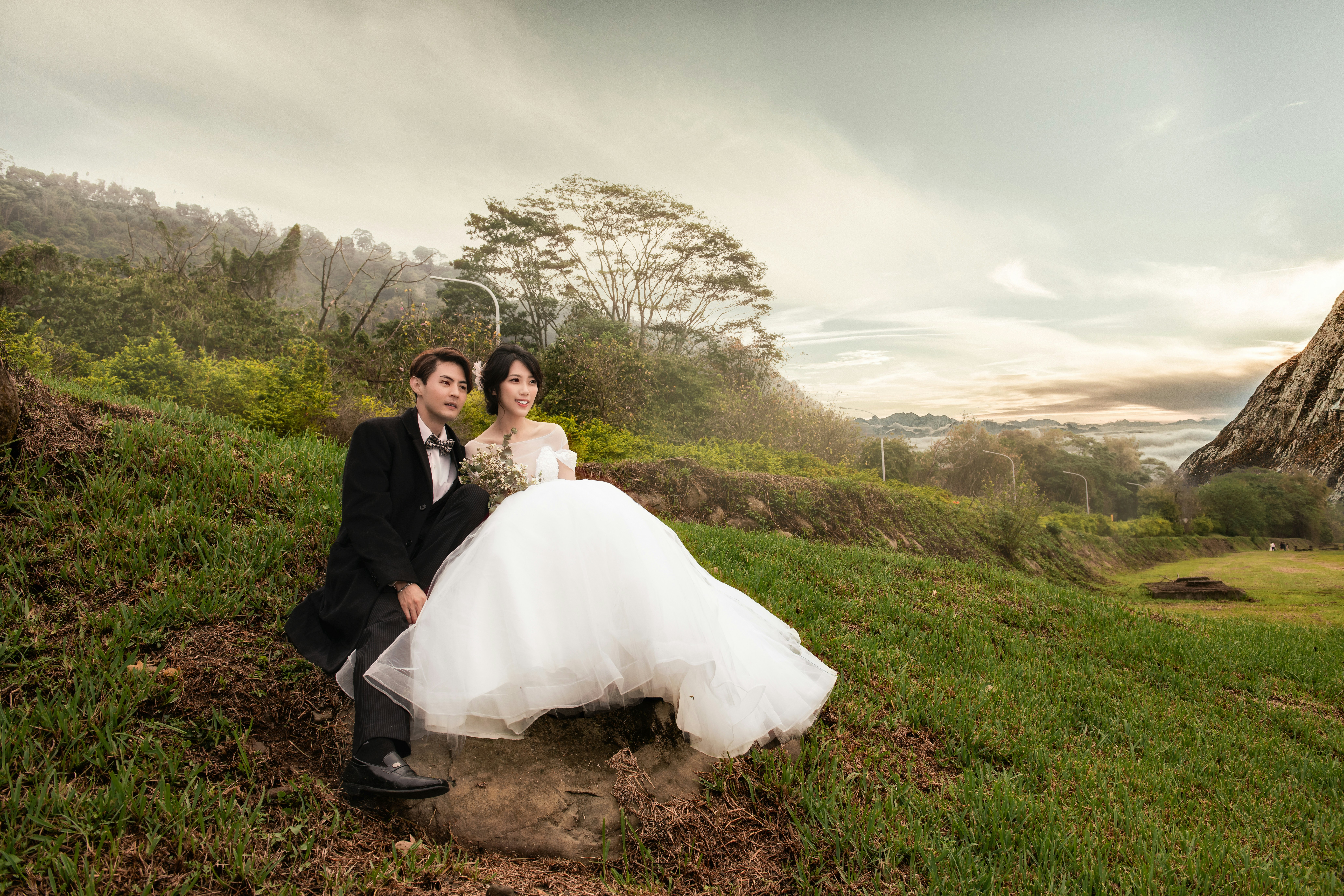 wedding couple sits on stone