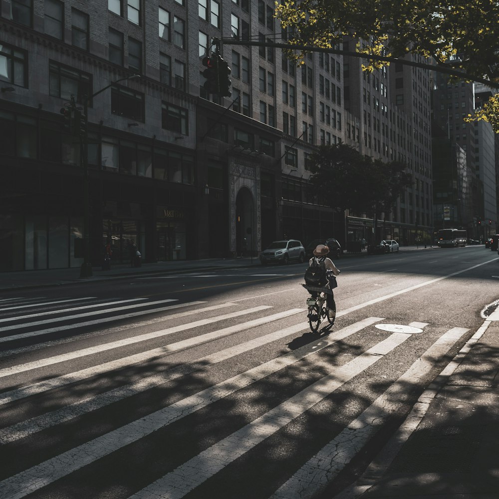 person riding on bicycle near buildings