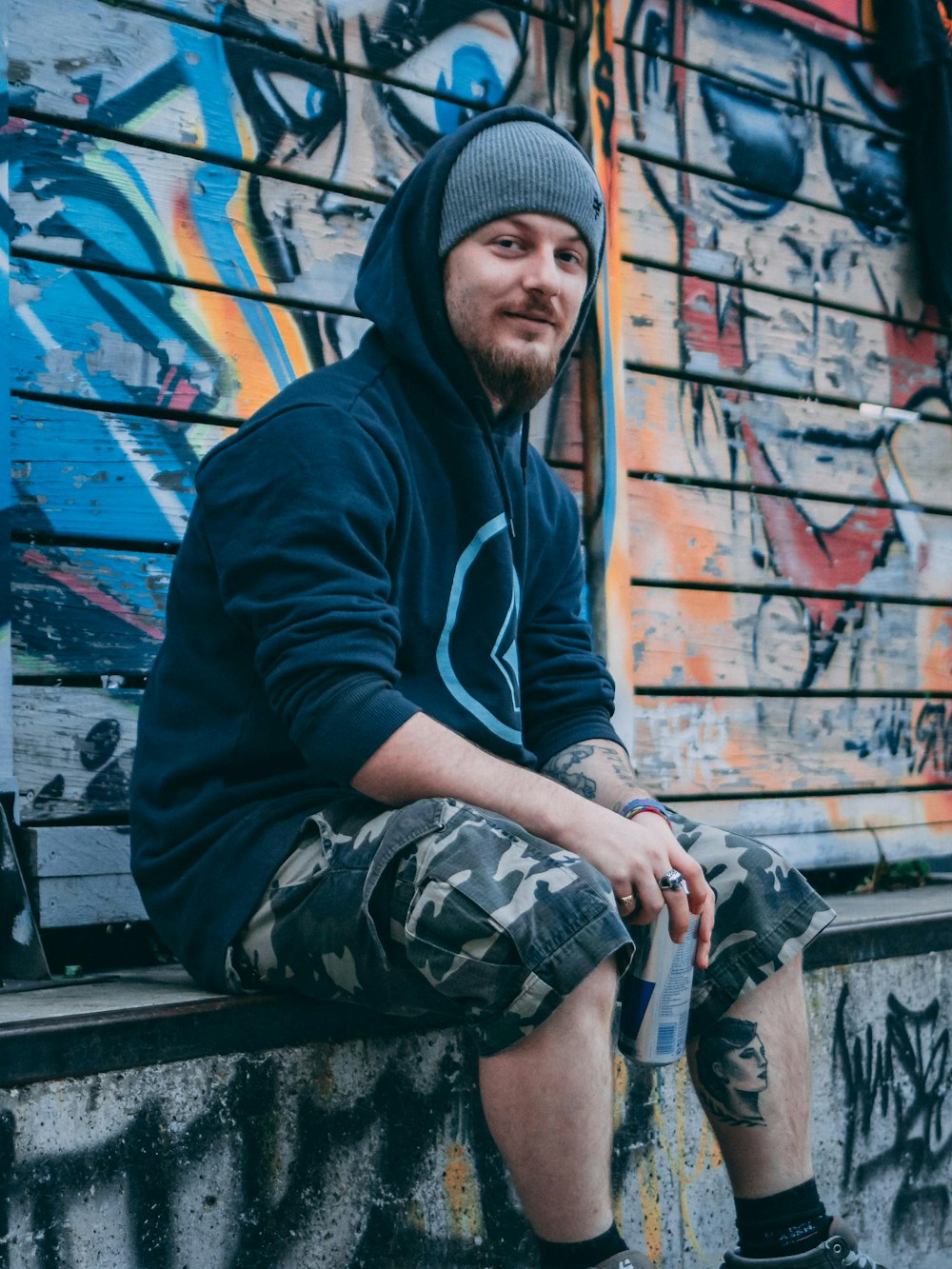man sitting on concrete seat with graffiti