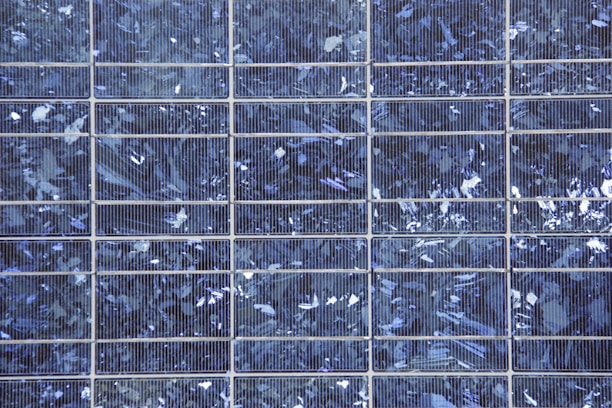A close-up of a solar panel with digital monitoring data overlay showing voltage and current readings.