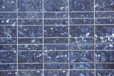 Close-up of polycrystalline solar panels reflecting sunlight.