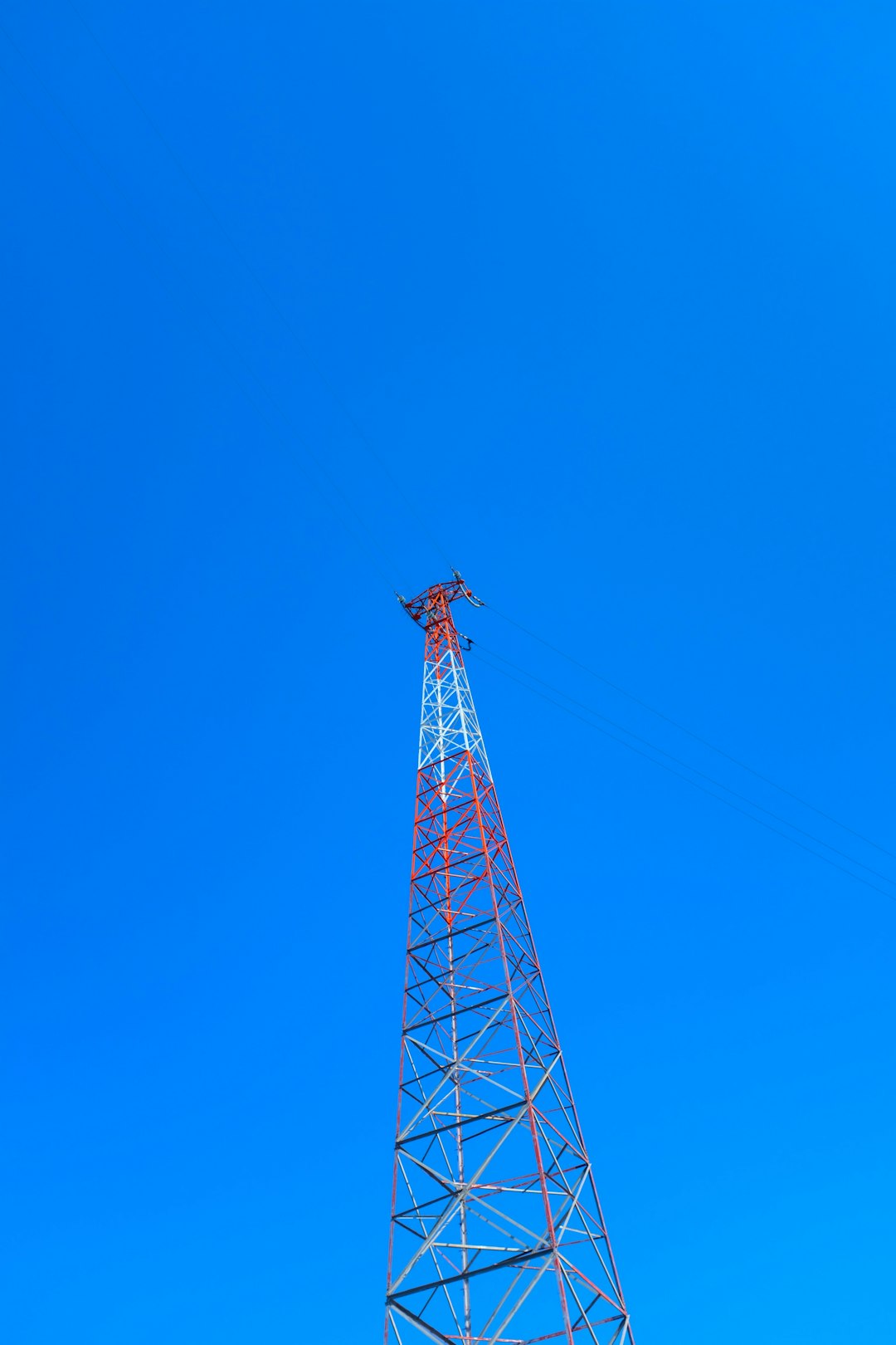 red and white metal tower under blue sky