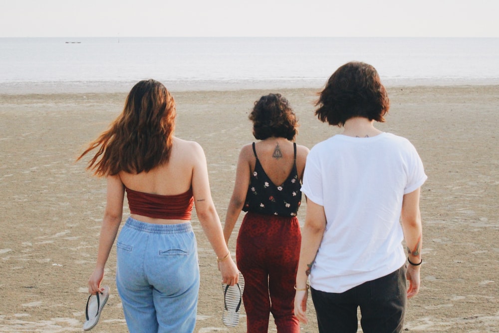 three women walking towards shoreline