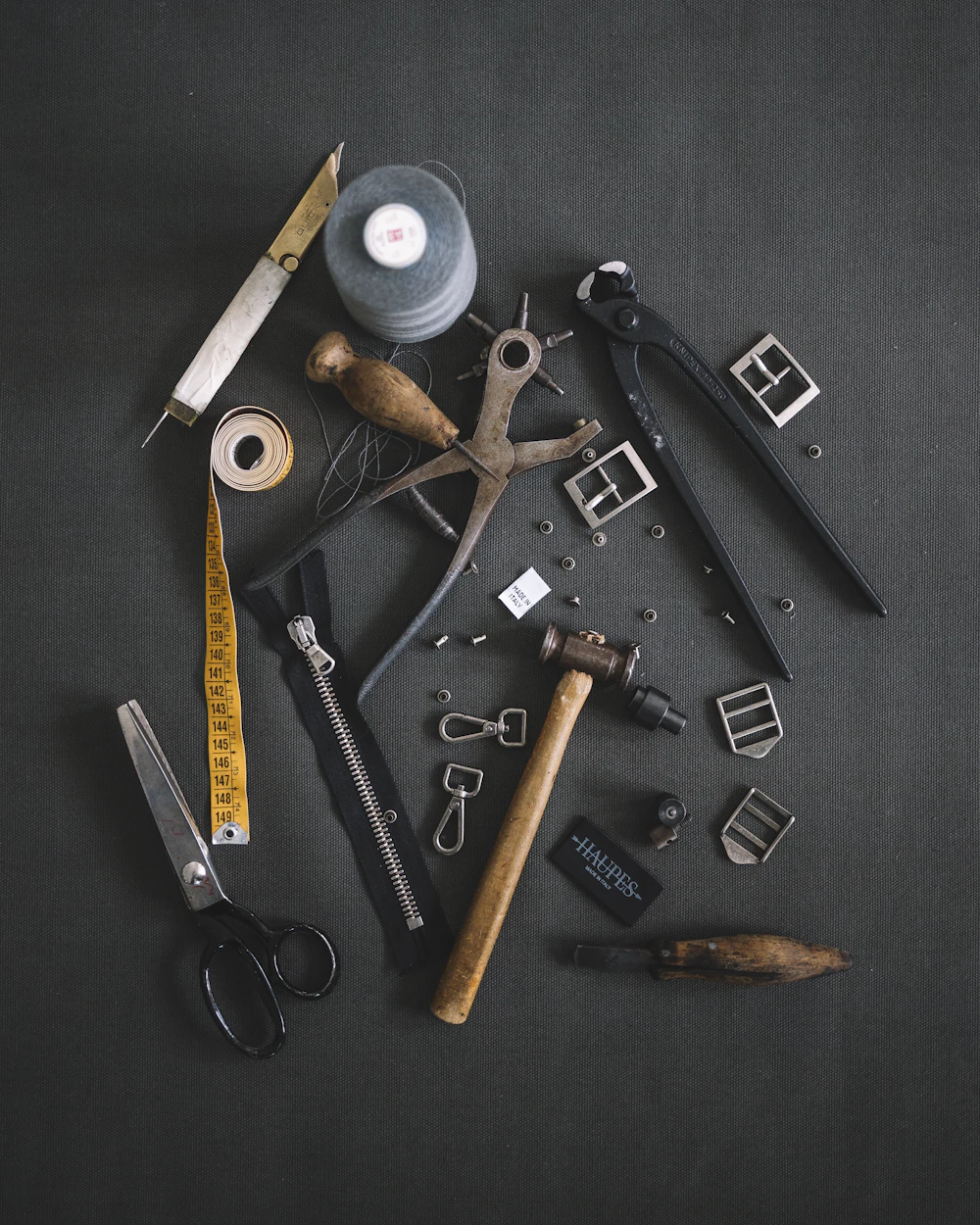 Traditional jewelry making tools laid out on a dark bench