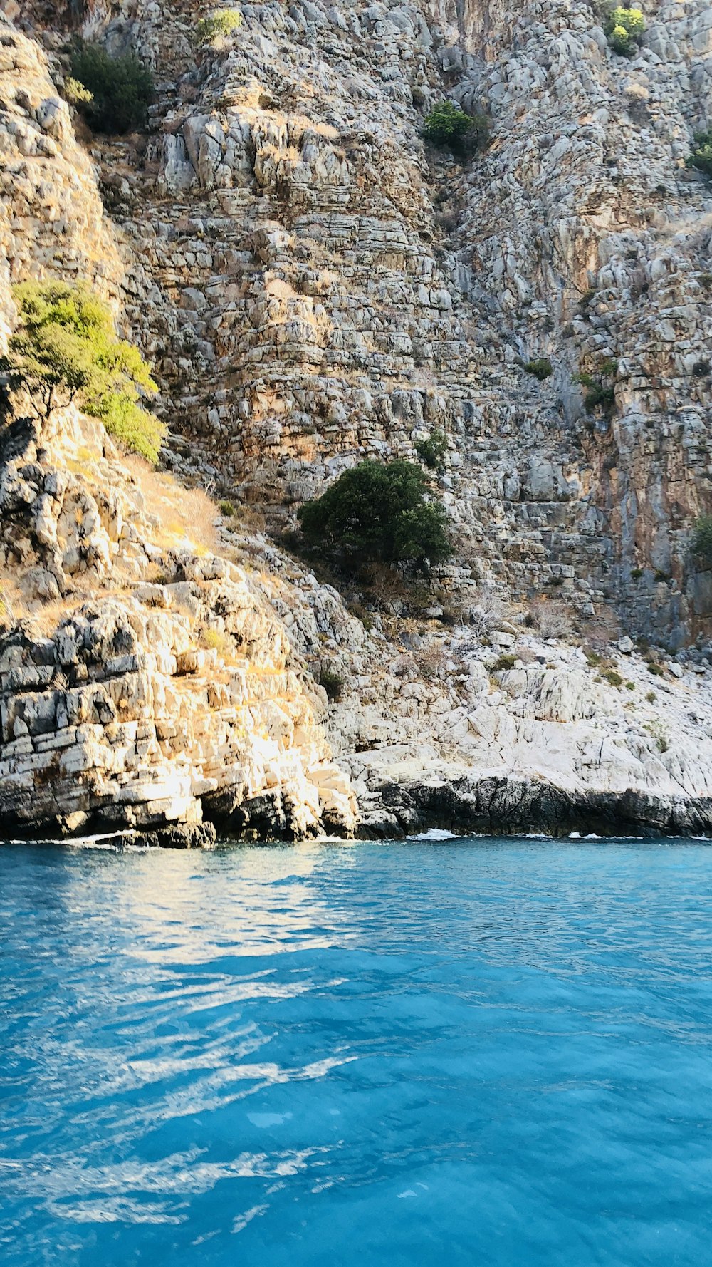 calm body of water near cliffs