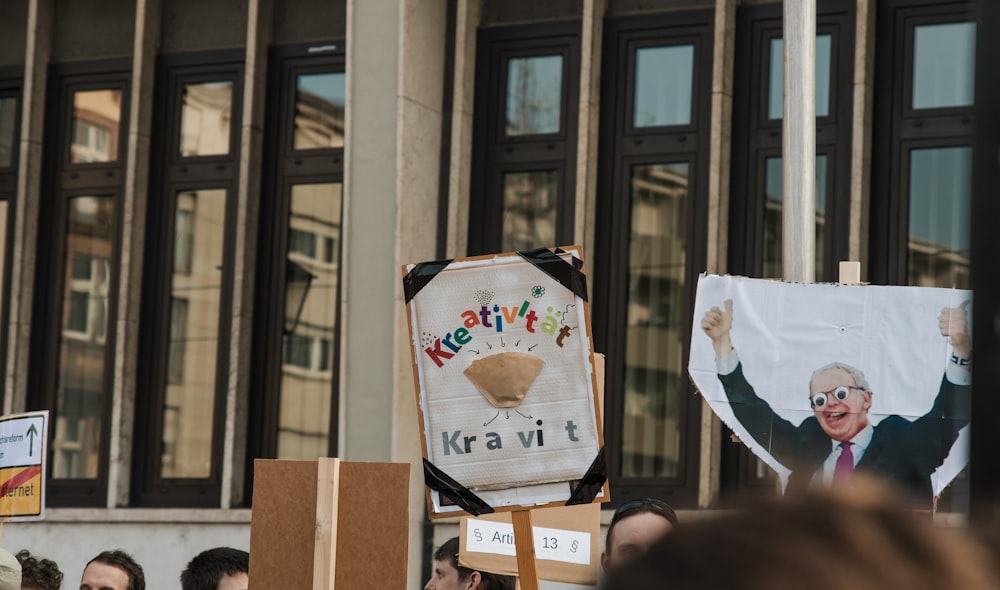 a group of people holding signs in front of a building