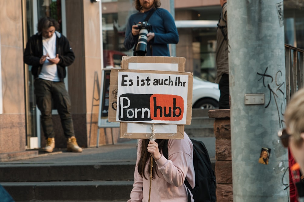Persona sosteniendo carteles de Pornhub