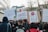 A group of people is participating in a protest, holding signs with messages against Article 13 and automated bots. One sign features binary code and a hashtag declaring 'NO BOTS', while another reads 'ARTIKEL 13' with 'NO UPLOAD FILTER'. A third sign displays a graphic with the text 'YOU SHALL NOT BE PASSED'. The crowd is gathered on a street lined with buildings and trees, and it appears to be daytime.