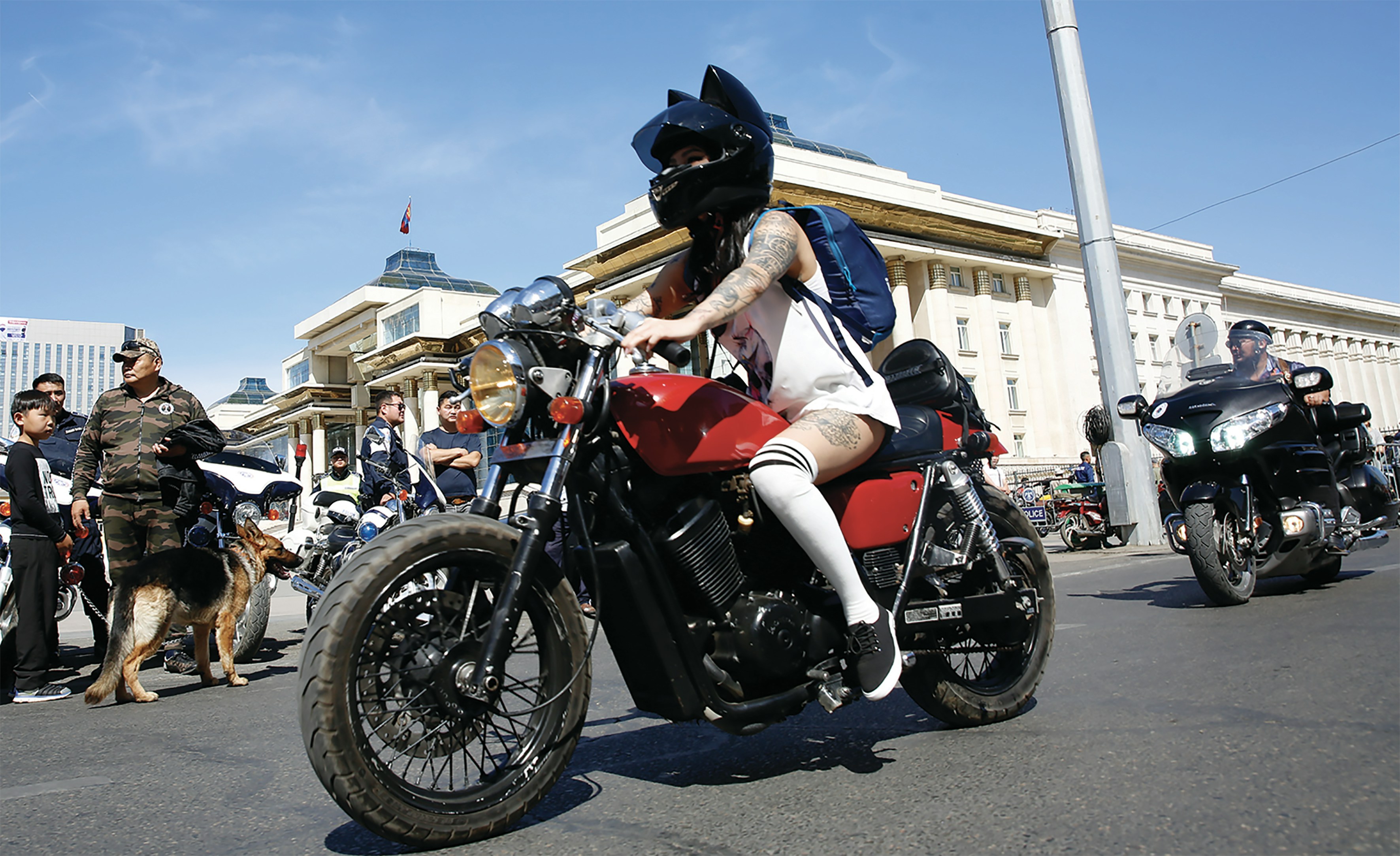 orang yang mengenakan tank top putih mengendarai sepeda motor merah