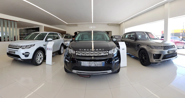 A sleek, modern car dealership showroom with imported cars on display.