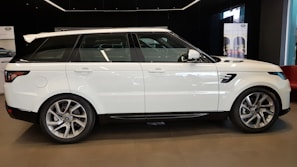 Robust white SUV displayed under soft lighting in a premium dealership setting
