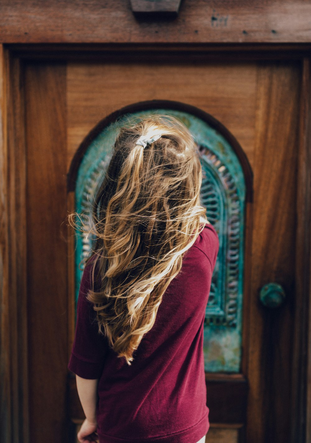 man wearing red sweater in front of door