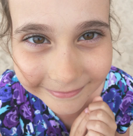 A close-up of a child’s joyful face as they receive a handmade gift card.