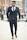 Close-up of a man confidently walking down a city street in trendy menswear.
