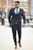 A well-dressed man in a stylish outfit, confidently walking down a city street.
