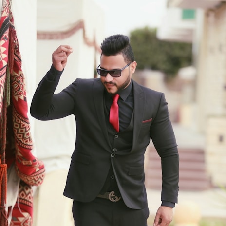 A stylish gentleman wearing a tailored African-inspired suit, smiling confidently.