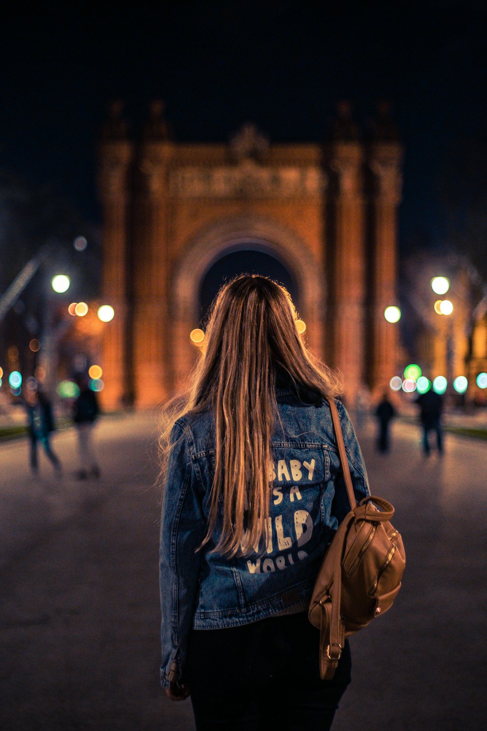 Mujer con mochila de pie frente al monumento