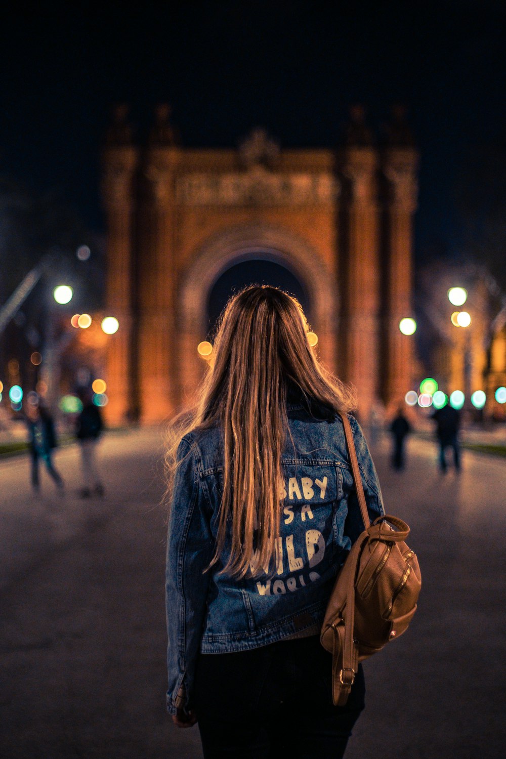 mulher usando mochila em pé na frente do monumento