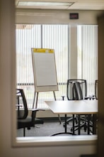 white wooden table near black rolling chairs
