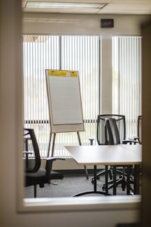 Board room strategy. White board adjacent to a wooden table.