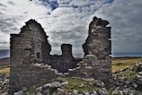 Wide shot of ancient stone ruins under a cloudy sky, evoking timelessness.