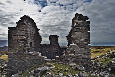 Wide shot of ancient stone ruins under a cloudy sky, evoking timelessness.