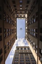 airplane flying on top of high rise buildings
