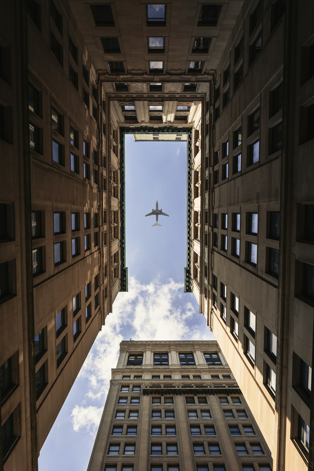 airplane flying on top of high rise buildings