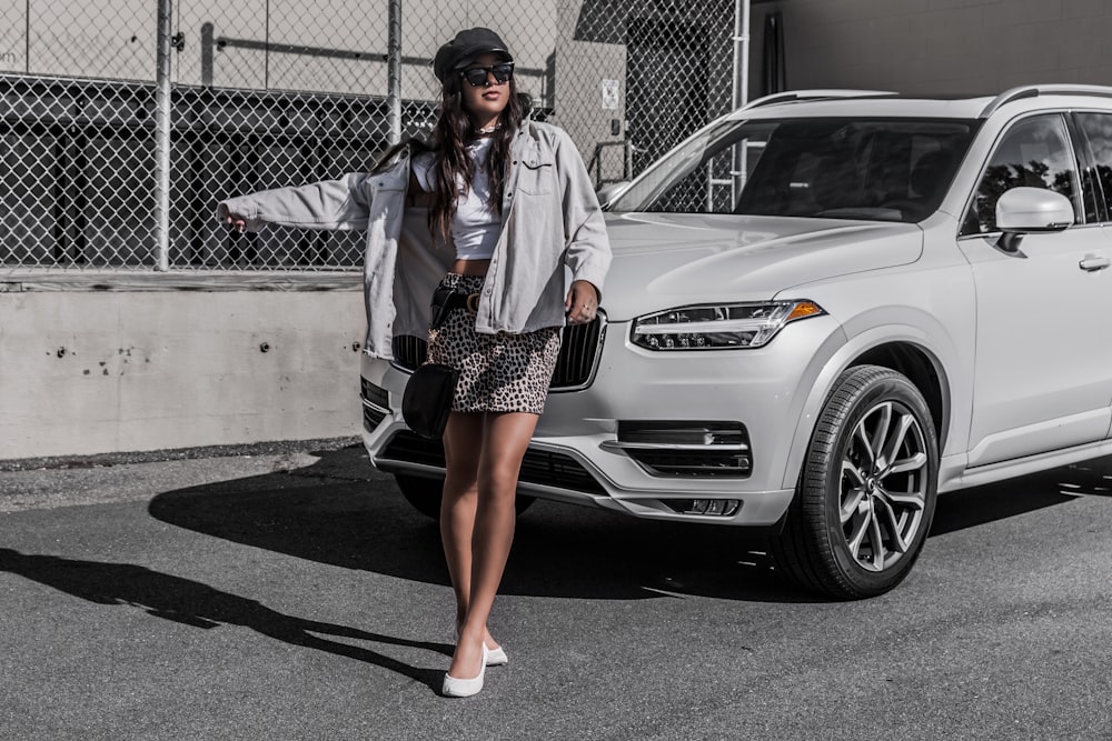 woman standing infront of whit SUV