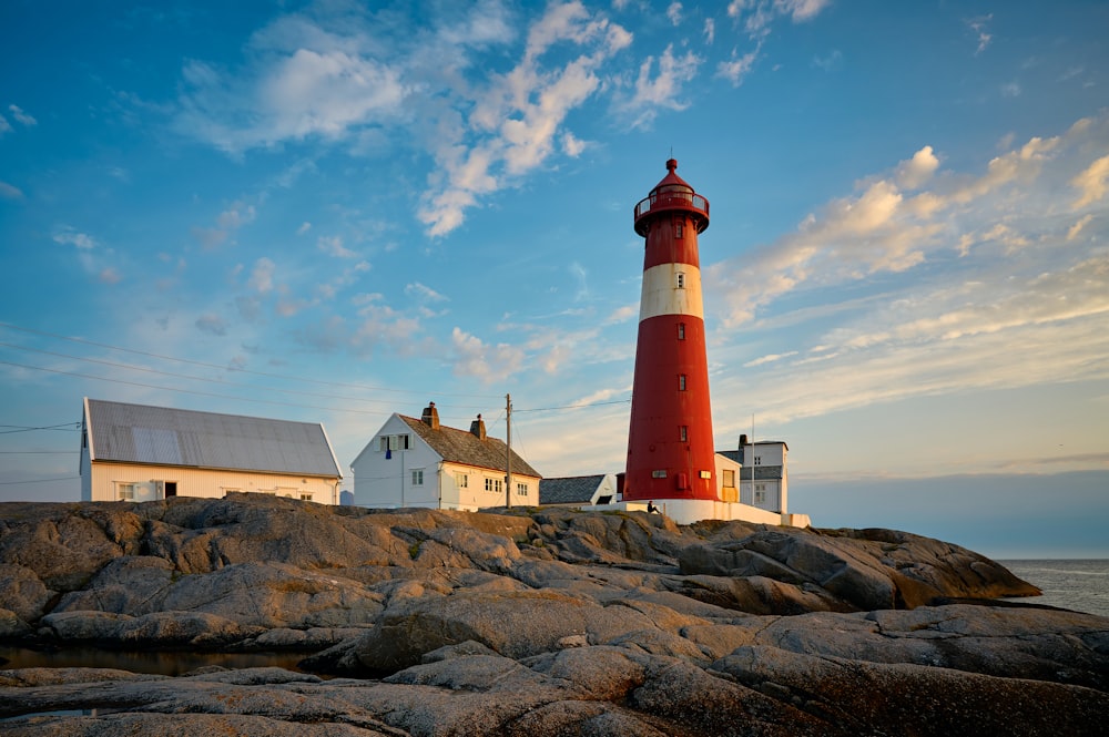 red and white lighthouse near shore during daytime