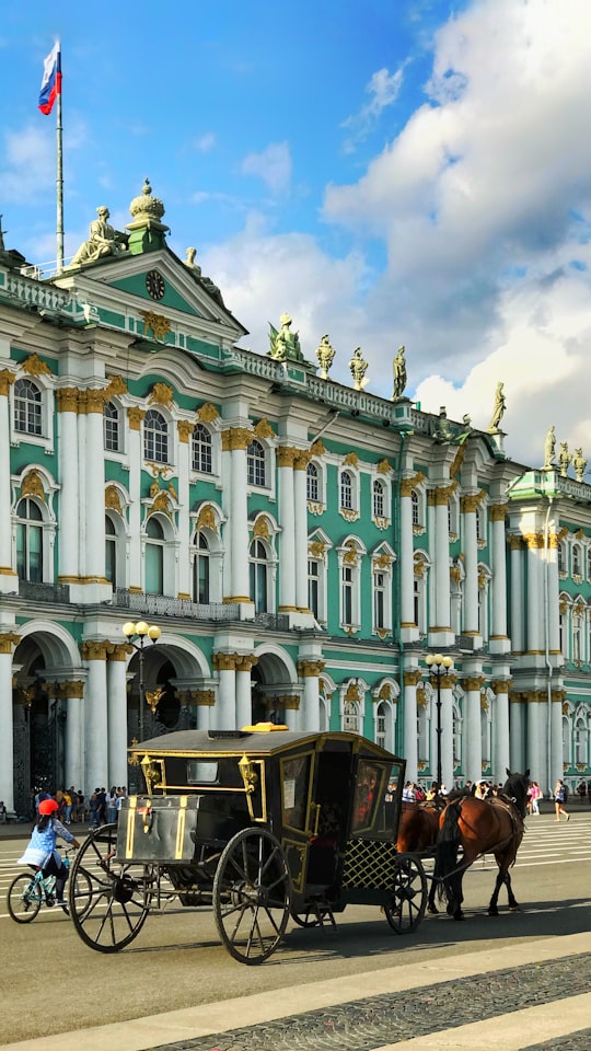 horse with carriage running beside building in Winter Palace Russia