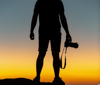 silhouette of man standing on cliff