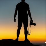 silhouette of man standing on cliff