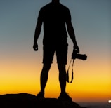 silhouette of man standing on cliff