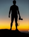 silhouette of man standing on cliff