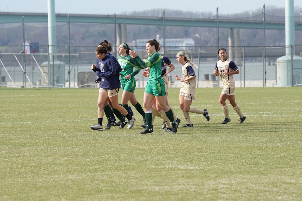 women in different jerseys running on green field during daytime