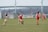 A group of women playing football together on a sunny field.