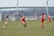 A group of women playing football together on a sunny field.