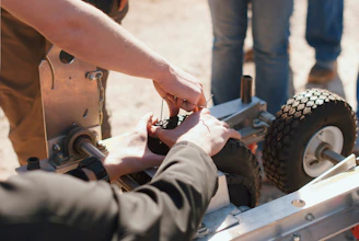 A friendly family team repairing construction and gardening machines in a bright workshop.