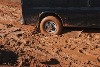black car stuck on mud