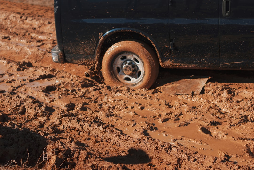 black car stuck on mud,