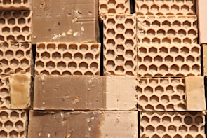 Fresh beeswax blocks stacked neatly with a honeycomb pattern visible.