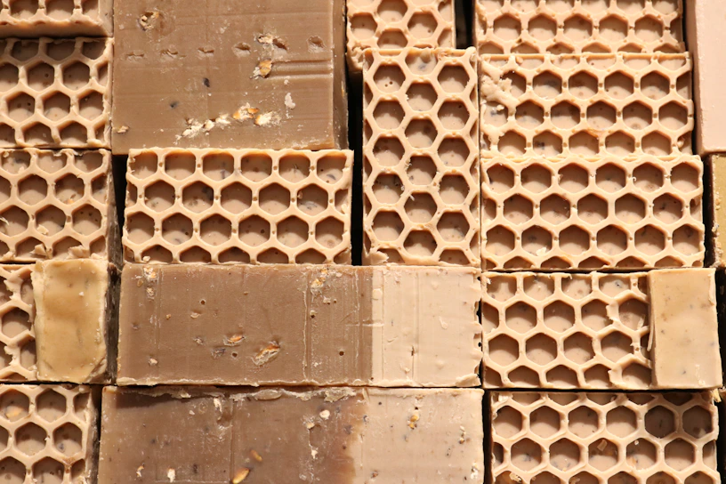 Close-up of golden beeswax blocks freshly processed, glowing warmly in natural light.