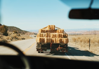 a truck is loaded with hay on the side of the road