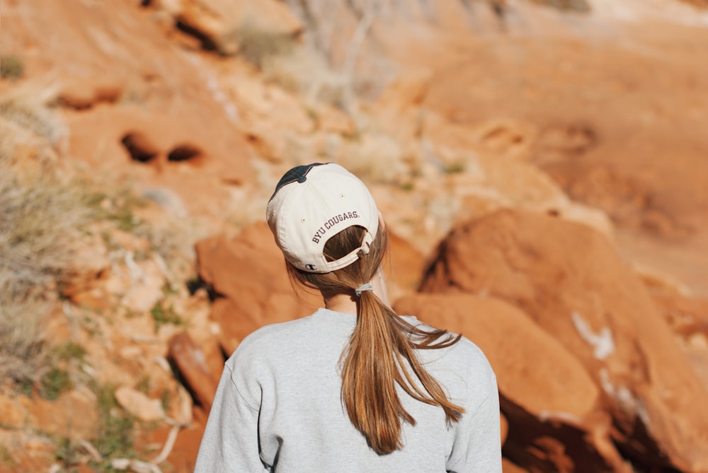 a woman with a ponytail standing in front of a mountain