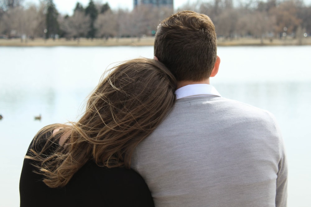 woman leaning head on man's shoulder