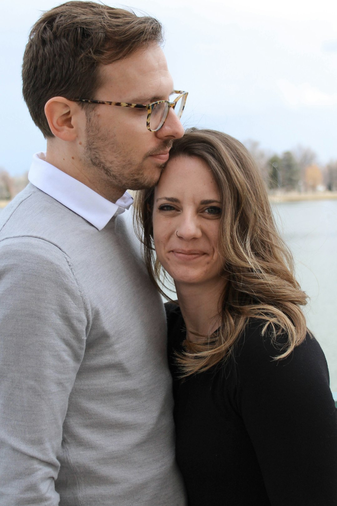 man and woman hugging near body of water